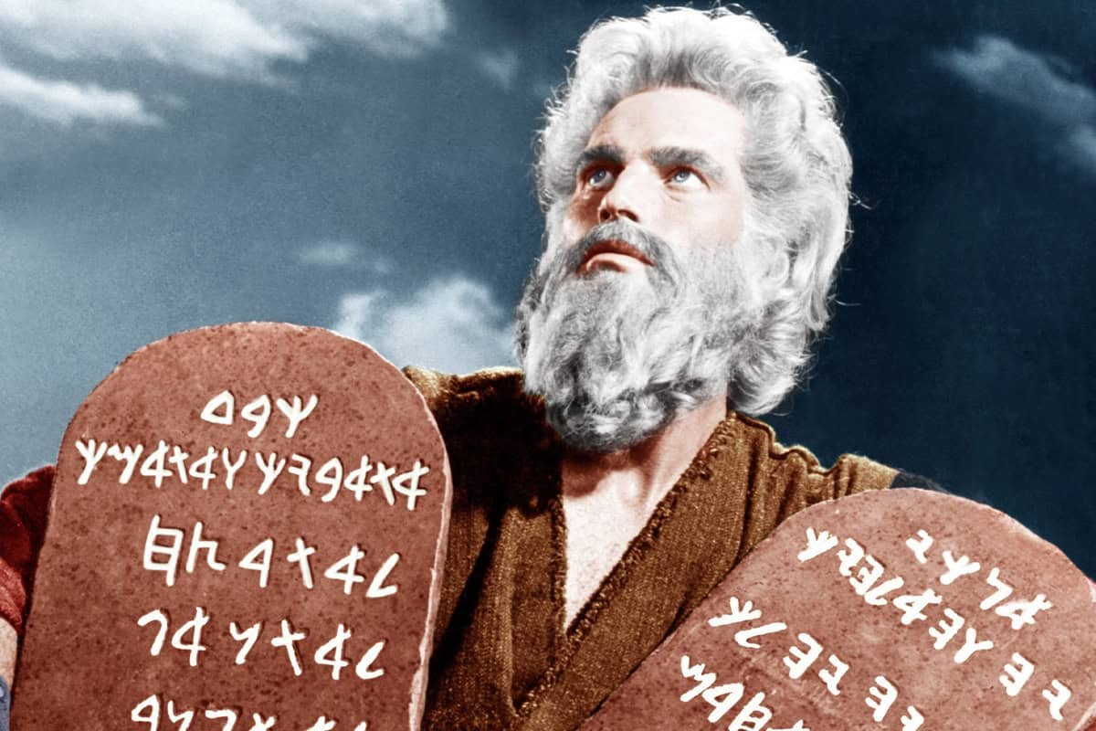 Bible character holding two tablets with ancient script, close-up portrait image for religious or biblical-themed content.