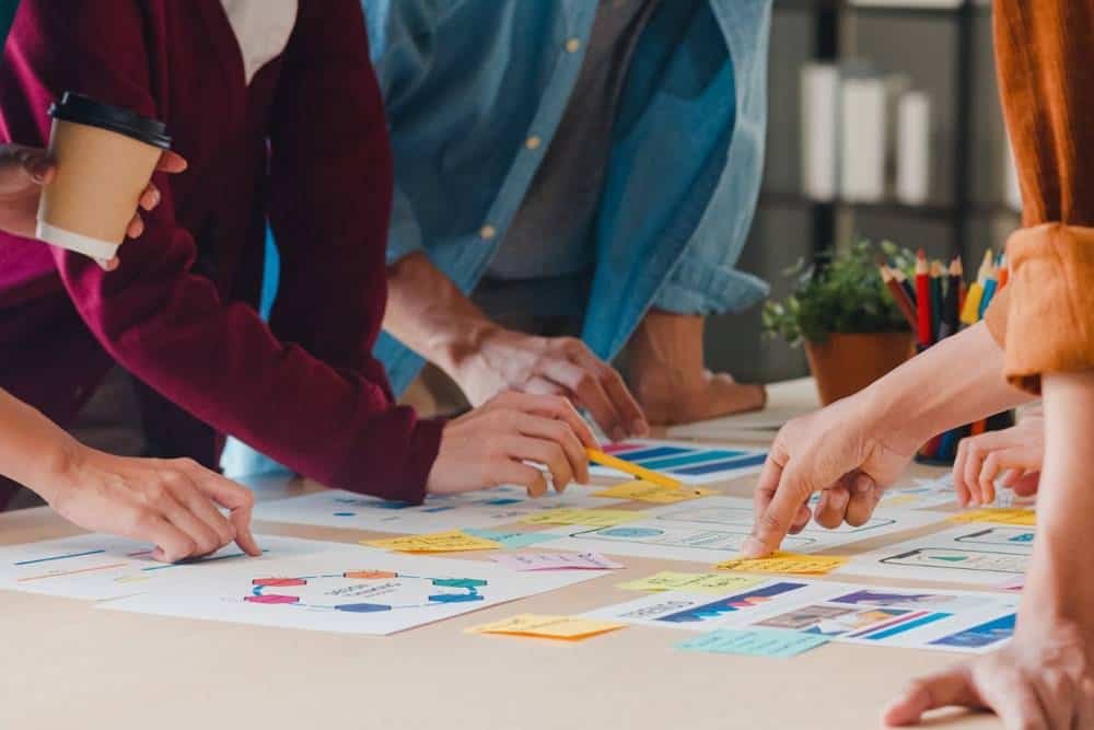 Stressed Business Team has a strategic planning meeting with visual charts and sticky notes in a modern office setting to develop project strategies.